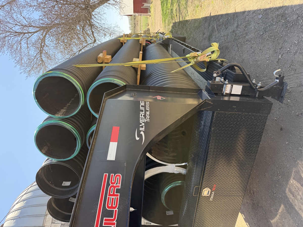 HDPE culvert pipe loaded and strapped on a Swenson Supply gooseneck trailer