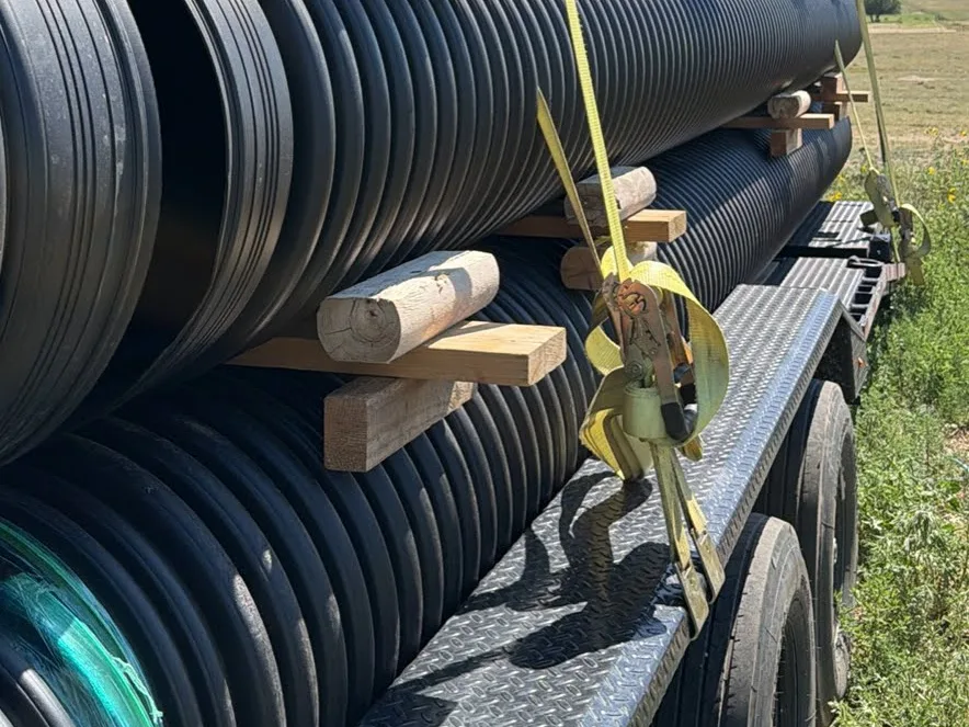 HDPE culvert pipe blocked and ratchet-strapped on the trailer