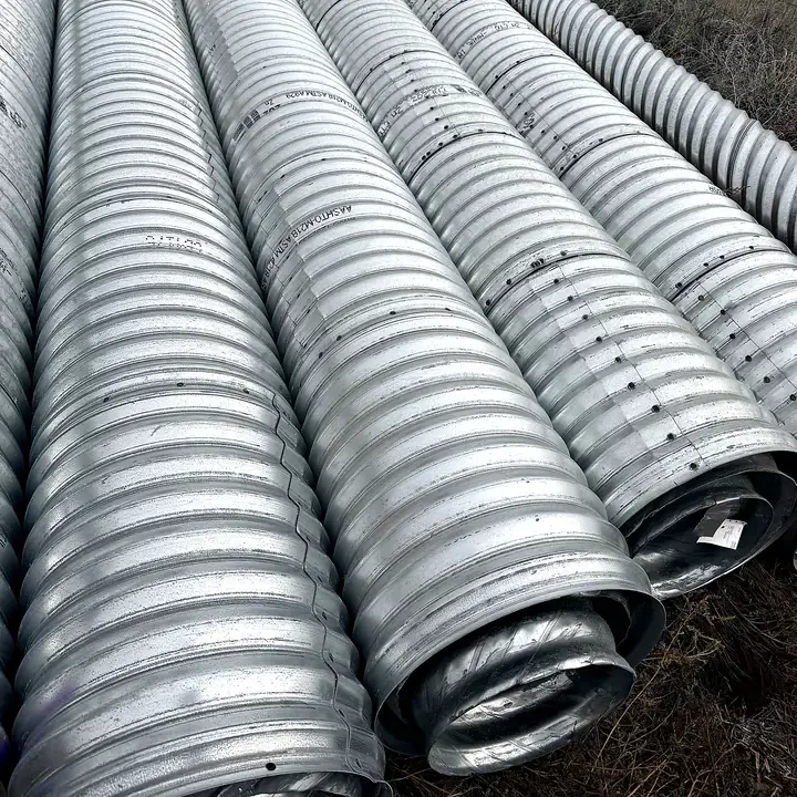 Galvanized corrugated metal culvert pipe lined up on the ground