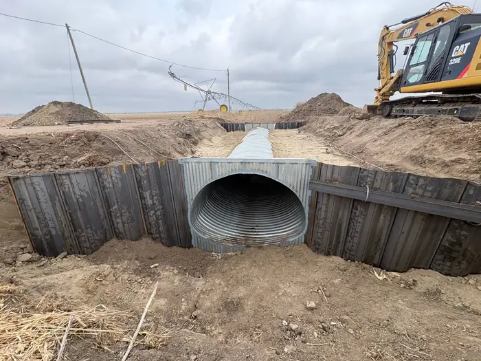 Corrugated metal culvert installed with a headwall and wingwalls