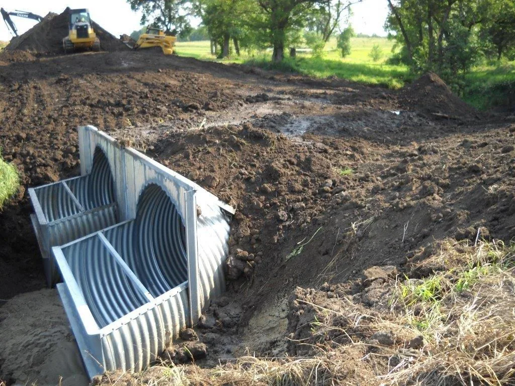Twin weir headwall in corrugated metal, two barrels set into a bank