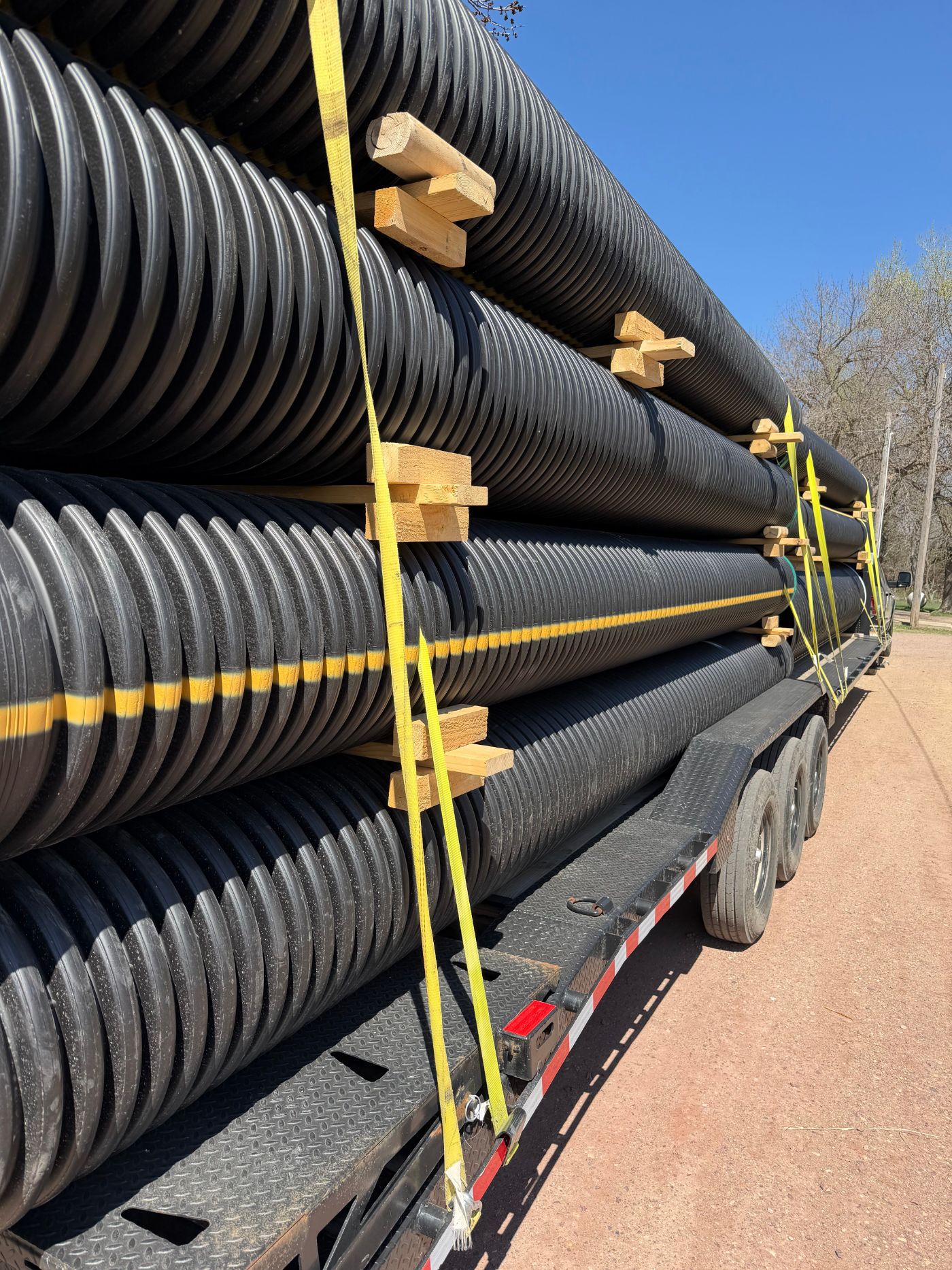 HDPE culvert pipe loaded and strapped on a Swenson Supply trailer