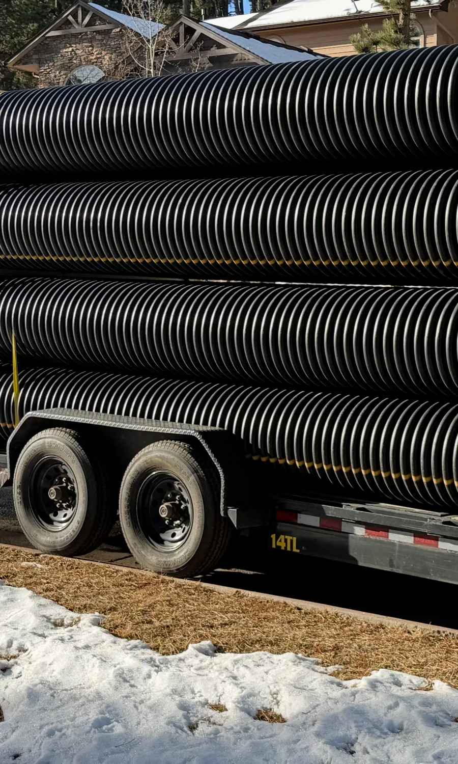 Culvert pipe delivered on a Swenson Supply trailer to a mountain home in winter